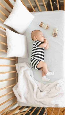 bébé qui dort dans un lit pour bébé
